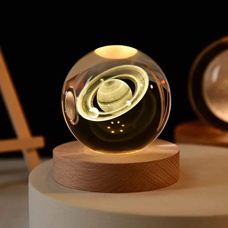 Tauche ein in die Schönheit des Universums mit der 3D Saturn Kristallkugel Lampe mit Holzsockel. Die hochwertige Kristallkugel zeigt den ikonischen Planeten Saturn mit seinen faszinierenden Ringen in einer präzisen 3D-Gravur, die durch das warme Licht lebendig wirkt.