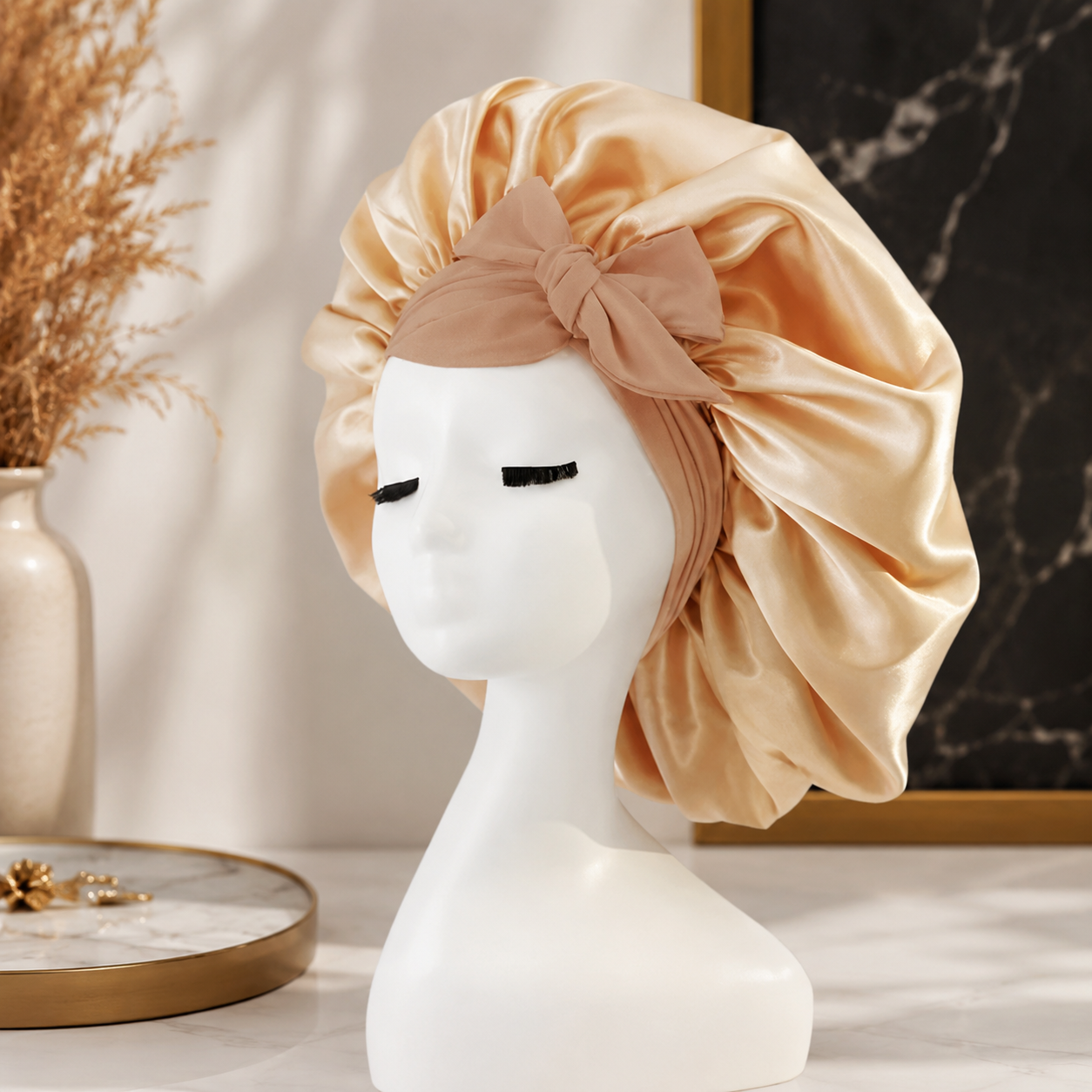 Luxuriöse Satin-Schlafhaube in elegantem Champagner mit dekorativer Schleife. Das glatte, seidige Material schützt das Haar während der Nacht, reduziert Reibung und hilft, Frizz sowie Haarbruch zu minimieren.