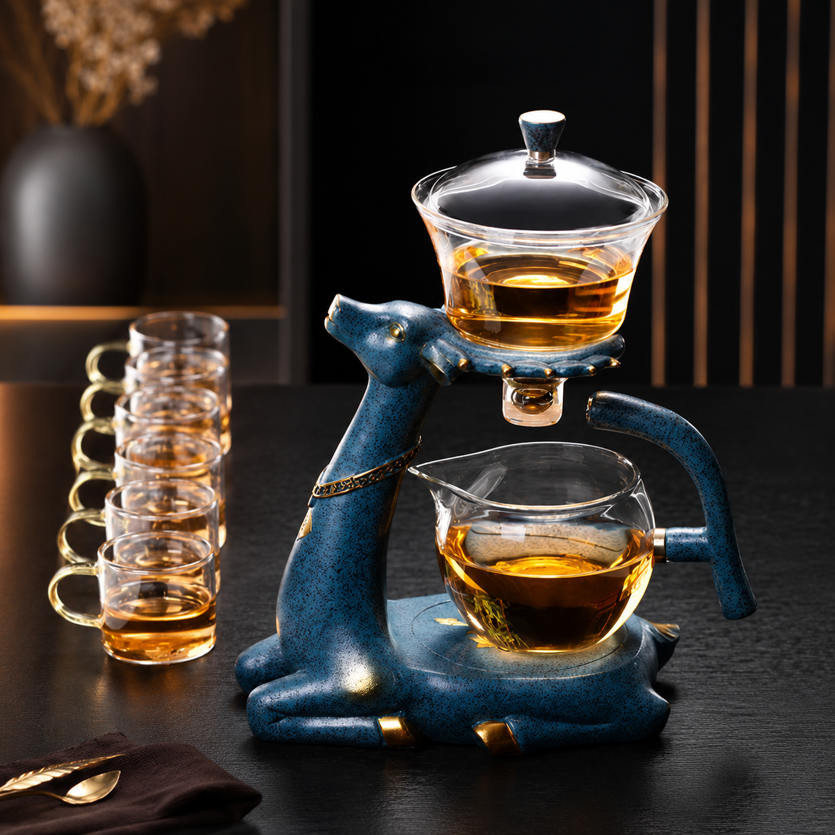 Elegante Glas-Teekanne mit hitzebeständigem Glaskessel und dekorativem blauem Metallständer für stilvollen Teegenuss.