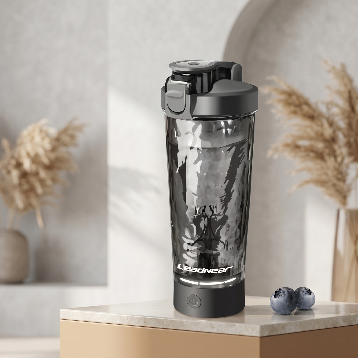 Rosa elektrischer Protein Shaker mit frischen Früchten auf einer Küchenarbeitsplatte