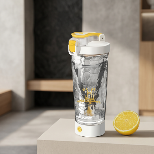 Elektrischer Protein Shaker mit transparentem Mixbehälter und gelbem Deckel neben einer Zitrone