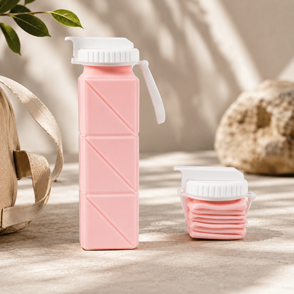 Rosa faltbare Silikon-Trinkflasche mit zusammengefaltetem Becher auf hellem Hintergrund.