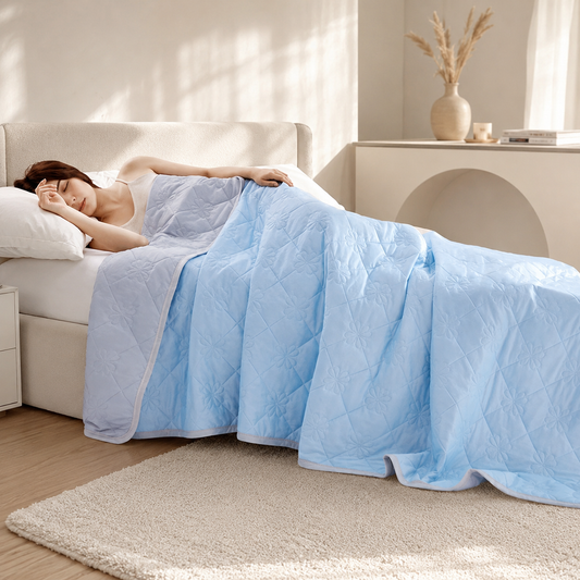 Moderne Schlafzimmerszene mit der kühlenden Sommerdecke in elegantem Blau auf einem gemütlichen Bett.
