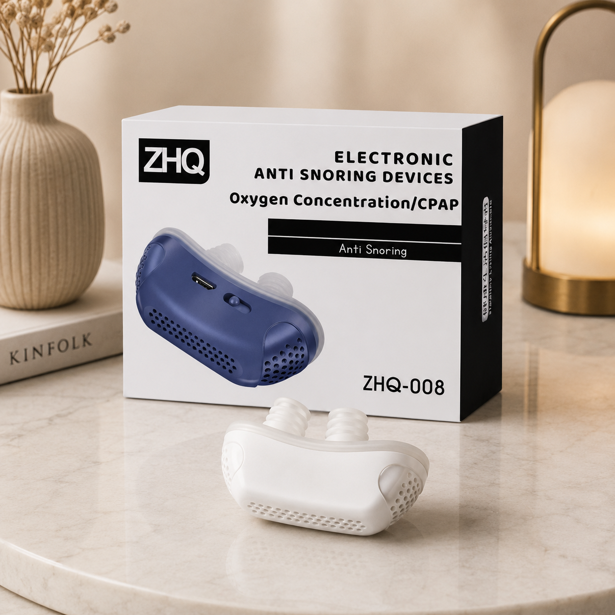 Dieses Bild zeigt die Produktverpackung eines modernen elektronischen Anti-Schnarch-Geräts zusammen mit dem Gerät in der Farbvariante Weiß. Die hochwertige Verpackung mit klarer Gestaltung und die stilvolle Präsentation auf einer Marmoroberfläche vermitteln einen modernen und hochwertigen Eindruck.