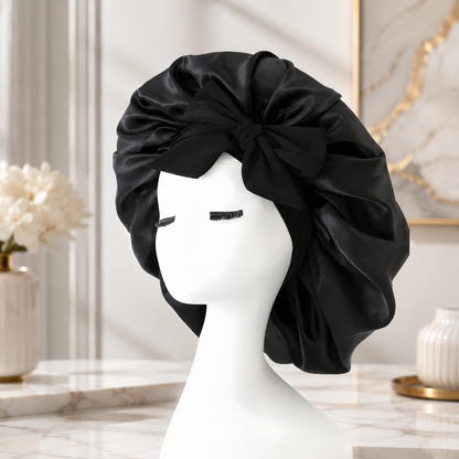 Elegante schwarze Satin-Schlafhaube mit dekorativer Schleife für stilvollen Schutz während der Nacht.