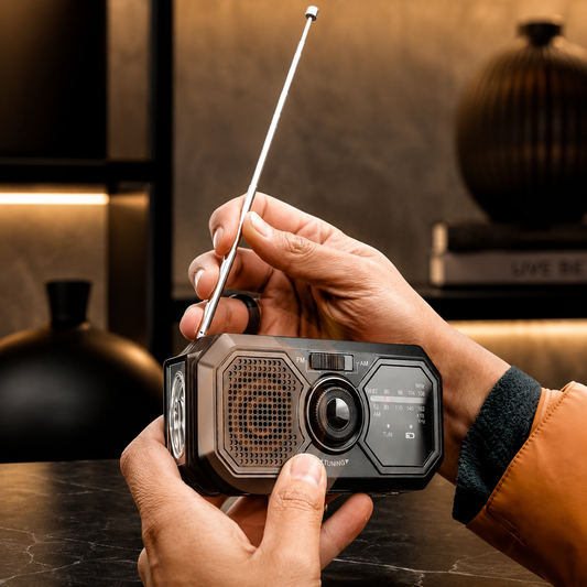 Person hält ein tragbares Retro-Radio mit Bluetooth, Lautsprecher und ausgezogener Antenne in der Hand.